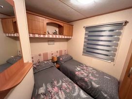 A bedroom with two beds and storage at a property near West Mersea