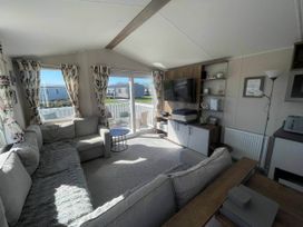 A living room with a television and seating area at Near Flookburgh
