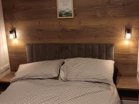 A bedroom with a bed and bedside lamps at The Old Barn Near Flookburgh