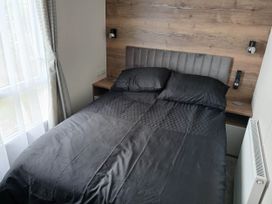 A bedroom with a bed and nightstand at The Old Barn in Near Flookburgh