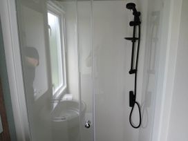 A shower with a glass door and a sink in a bathroom near Flookburgh