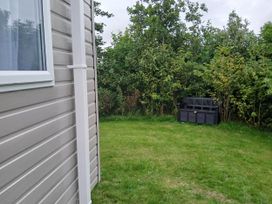 A garden with a seat beside bushes at a property near Flookburgh