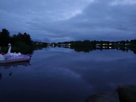 A view of a lake with a swan paddle boat at a location near Flookburgh