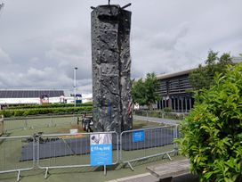 An outdoor climbing wall surrounded by mats and fences at a recreational area near Flookburgh