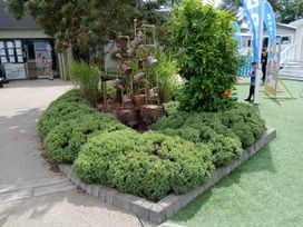 An outdoor area with bushes and a tree at a recreational facility near Flookburgh