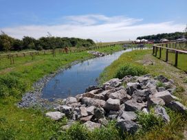 A stream with rocks and grass at a nature area near Flookburgh