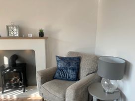 A living room with an armchair and fireplace at The Old Barn in Bridlington
