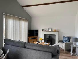 A living room with a sofa, TV, and a fireplace at The Old Barn in Bridlington