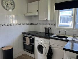 A kitchen with an oven, washing machine, and sink at The Old Barn in Bridlington