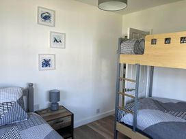 A bedroom with a bunk bed and twin bed at The Old Barn in Bridlington