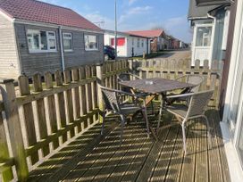A deck with a table and chairs at a property in Bridlington