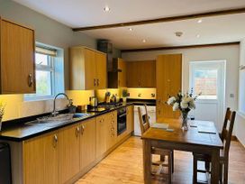 A kitchen with wooden units and a table at Nebo near Penygroes