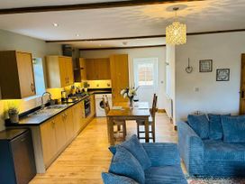A kitchen with a dining table and sofa at The Old Barn in Nebo near Penygroes