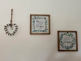 Decorative wall with framed quotes and a heart hanging at a property in Nebo near Penygroes