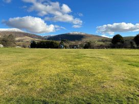 A grassy area with mountains in the background at a property near Penygroes