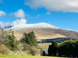 A snowy mountain with trees and a house at Nebo near Penygroes