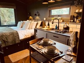 A bedroom with a kitchen area and dining table at The Old Barn in Newton Abbot