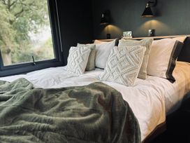 A bedroom with a bed and pillows at The Old Barn in Newton Abbot