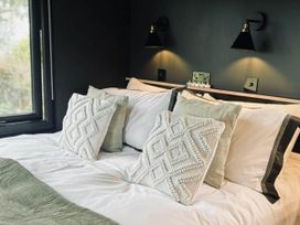 A bedroom with a bed and pillows at The Old Barn in Newton Abbot