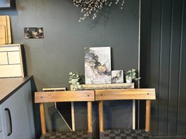 A kitchen with a wooden stool, counter, and decorative art at the property in Newton Abbot