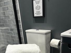 A bathroom with a toilet and a sign at The Old Barn in Newton Abbot