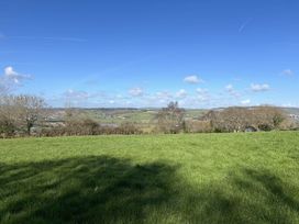 A view of hills and trees under a blue sky at a location in Newton Abbot