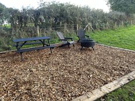 An outdoor seating area with a picnic table and chairs at 'The Retreat' in Newton Abbot