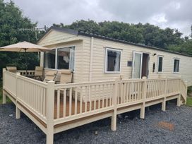 A cabin with a deck and outdoor furniture at a holiday park