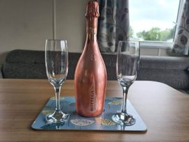 A bottle of champagne and two glasses on a table at The Old Barn in Manchester