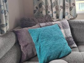 A sofa with cushions and curtains in a living room