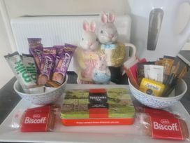 A kitchen counter with bowls of snacks and a tea tin at a property
