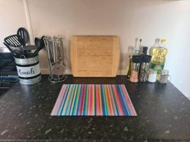 A kitchen countertop with utensils and a cutting board at 