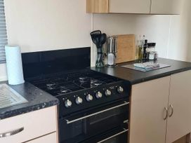 A kitchen with a gas stove and kitchen utensils at a property