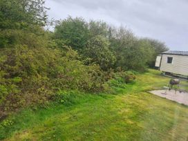 An outdoor area with bushes and a mobile home at a location