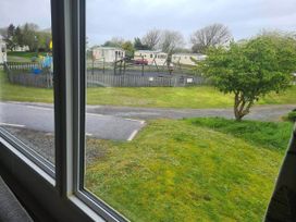 A view from a window showing a playground and holiday homes at a campground