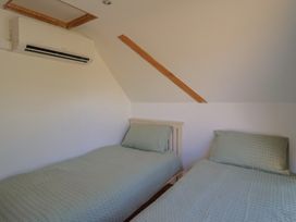 A bedroom with two single beds and an air conditioning unit at The Linhay Cotleigh Nr. Honiton