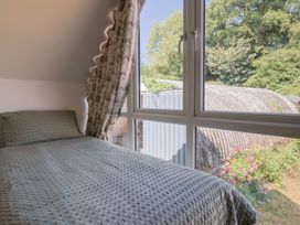 A bedroom featuring a bed and window overlooking a garden at The Linhay Cotleigh Nr. Honiton