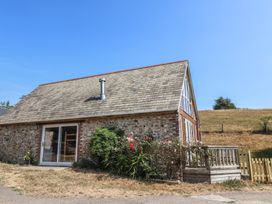 A house with a wooden deck and flowers in front at The Linhay Cotleigh Nr. Honiton