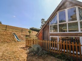 An outdoor area with a slide and wooden fence at The Linhay Cotleigh Nr. Honiton