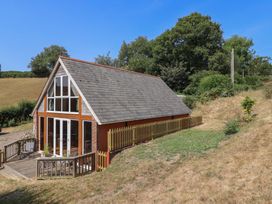 A house with a deck and fence in a grassy area at The Linhay Cotleigh Nr. Honiton