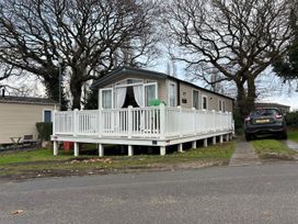 A mobile home with a deck and a car at Rockley Park in Poole