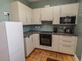 A kitchen with cabinets and appliances at Farnecrest in Seahouses