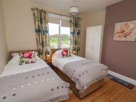 A bedroom with two beds and curtains at Farnecrest in Seahouses