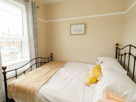 A bedroom with a bed and curtains at Farnecrest in Seahouses
