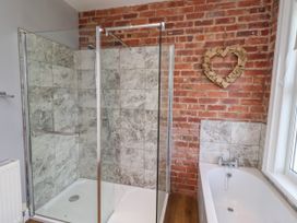 A bathroom with a shower and bathtub at Farnecrest Seahouses