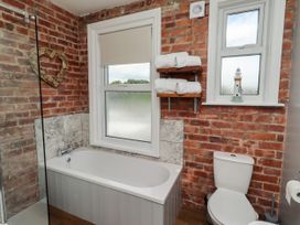 A bathroom with a bath tub and shower at Farnecrest in Seahouses
