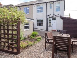 A garden with wooden table and chairs at Farnecrest in Seahouses