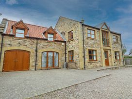 A house exterior with stone walls and a driveway at Alma House in Seahouses