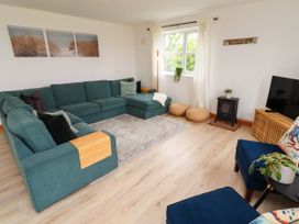 A living room with a sofa and a television at Alma House in Seahouses