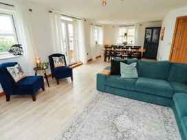 A living room with a sofa and dining table at Alma House in Seahouses